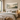 Infrarood fotopaneel met bosprint boven een bed in een moderne slaapkamer.